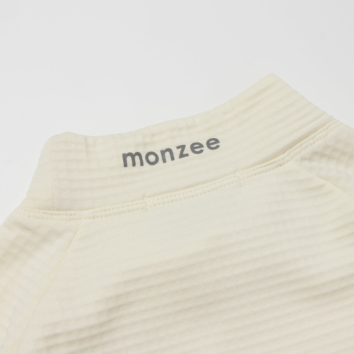 monzee ゴルフウェア ポーラーフリース ハイネック ホワイト - ディテール 背面ロゴ