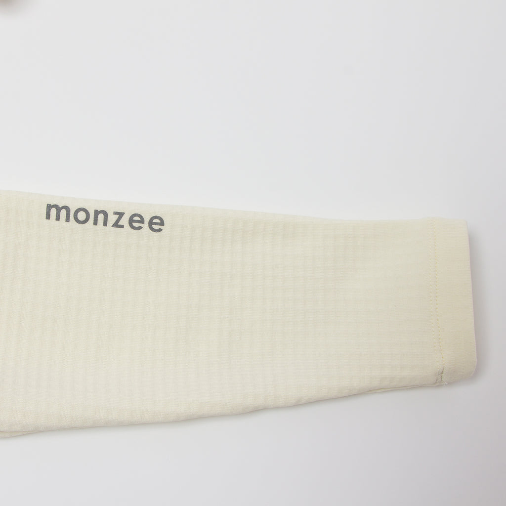 monzee ゴルフウェア ポーラーフリース ハイネック ホワイト - ディテール 袖ロゴ
