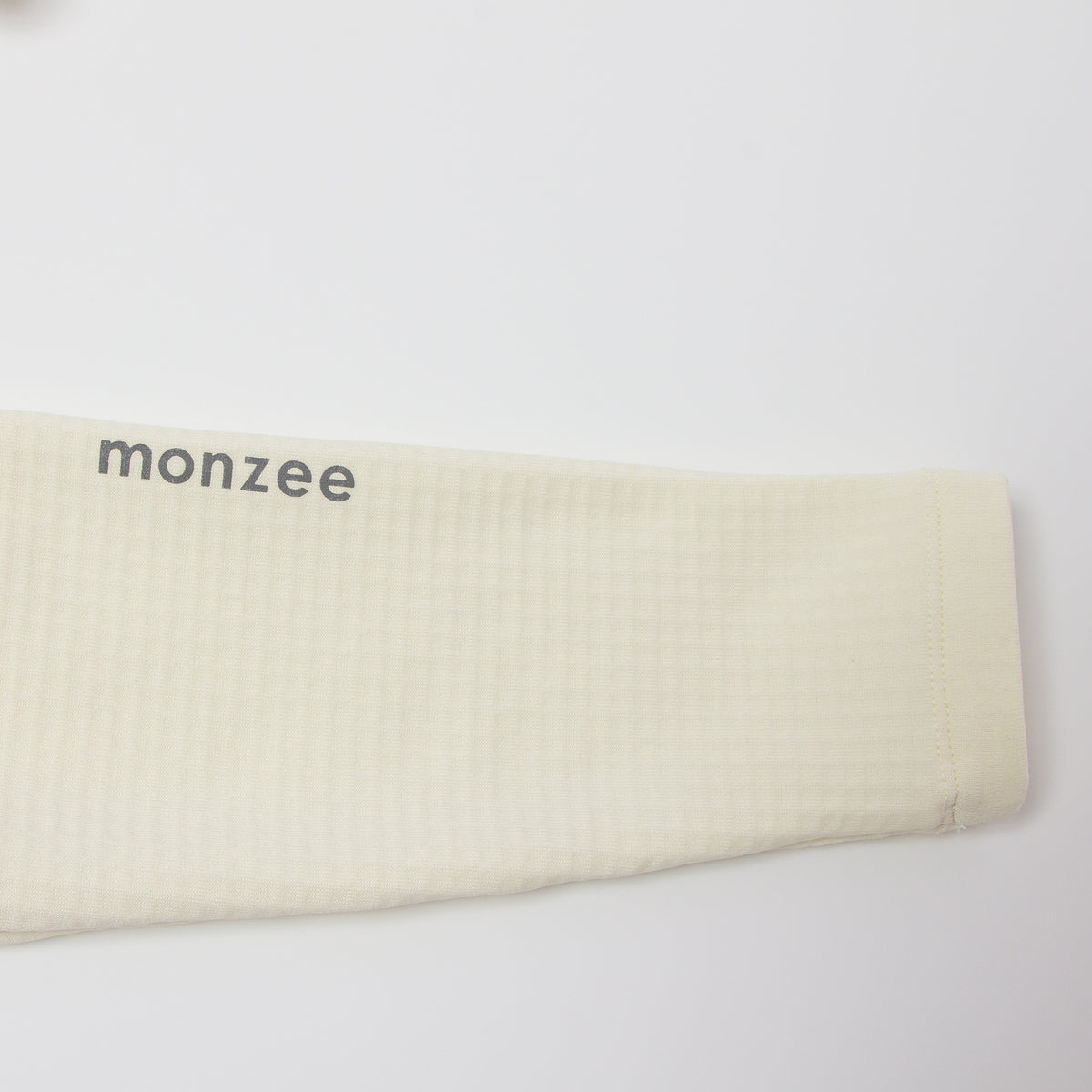 monzee ゴルフウェア ポーラーフリース ハイネック ホワイト - ディテール 袖ロゴ